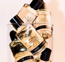Perfume bottles with visible branding on a light pink background